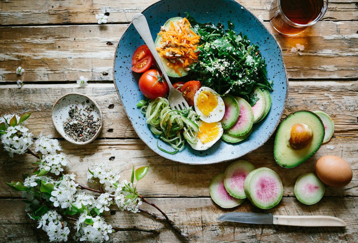 Healthy vegetables and fruits arranged on wooden surface